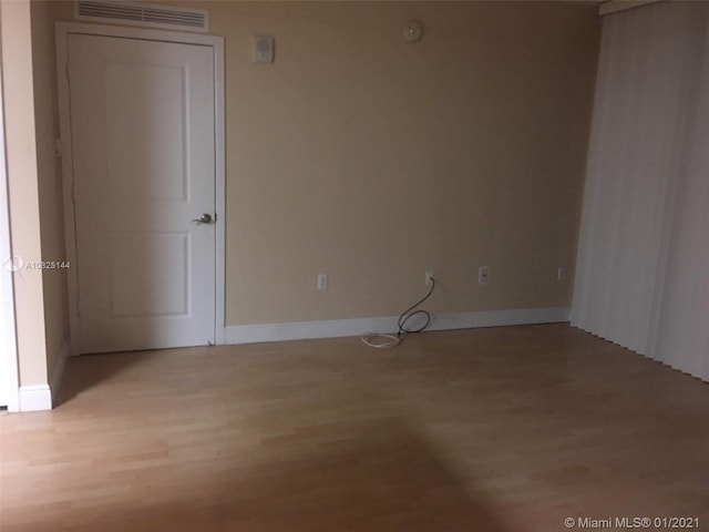 spare room with light wood-style flooring, baseboards, and visible vents