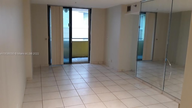 tiled spare room featuring floor to ceiling windows