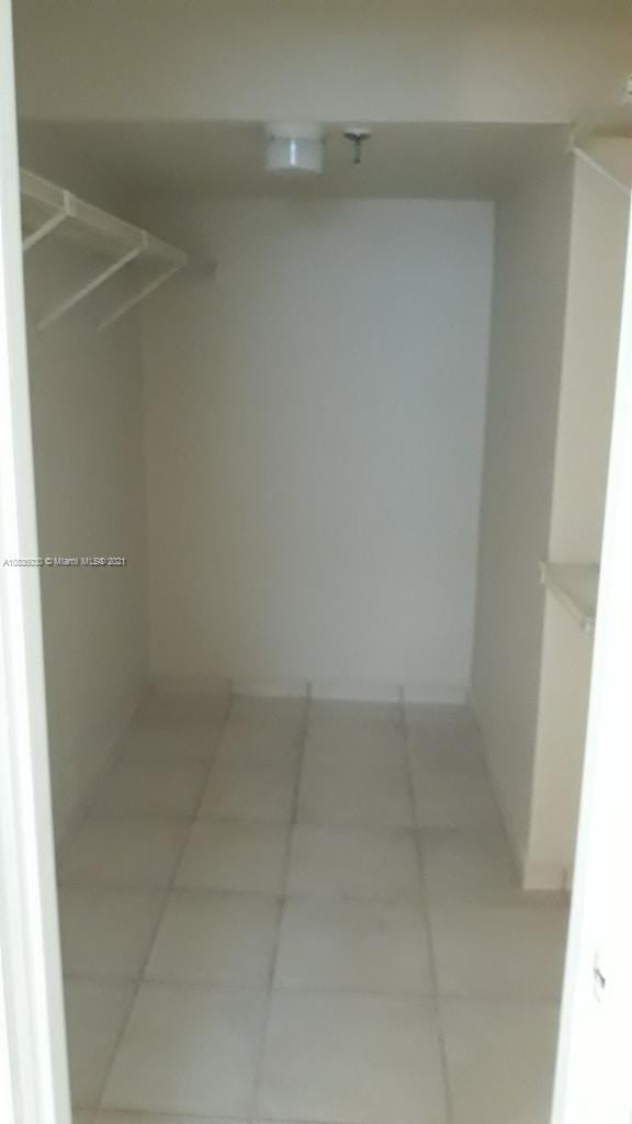 walk in closet with light tile patterned flooring