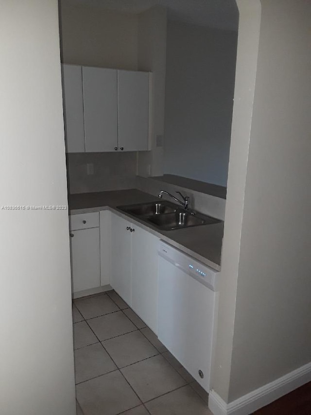 kitchen featuring dishwasher, light tile patterned floors, white cabinetry, and sink