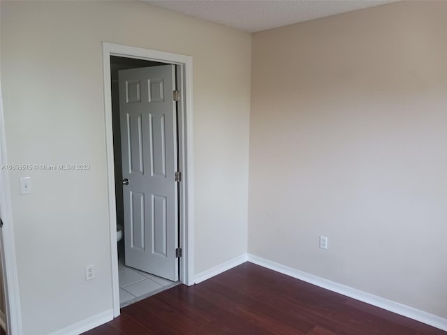 spare room featuring a textured ceiling and hardwood / wood-style flooring