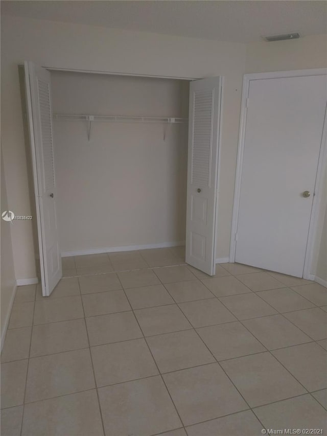 unfurnished bedroom featuring light tile patterned floors and a closet