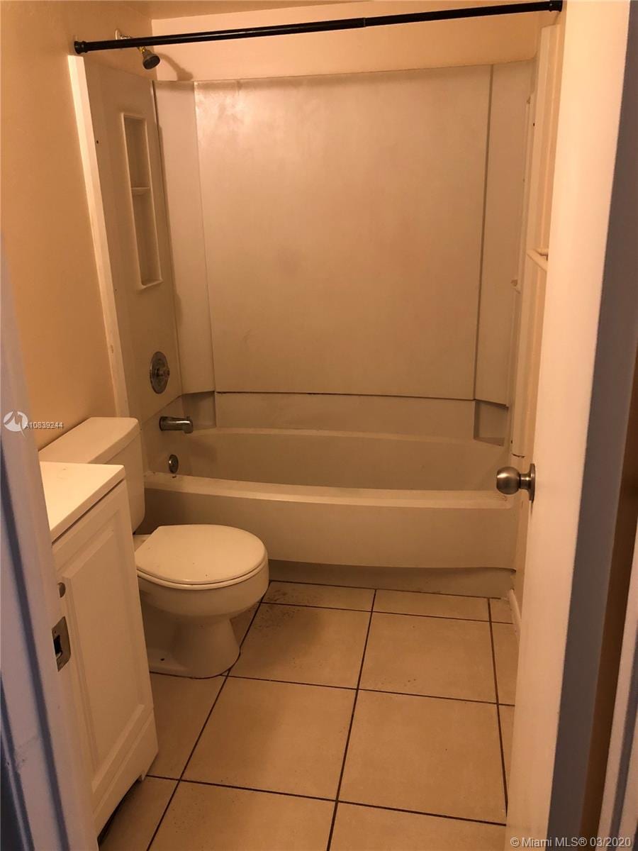 full bathroom featuring tile patterned flooring, vanity, bathtub / shower combination, and toilet