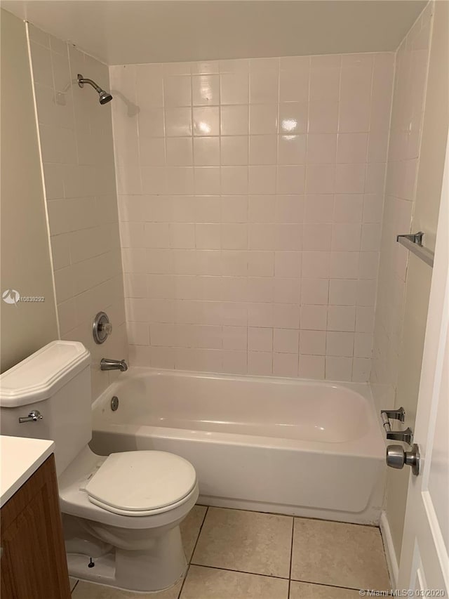 full bathroom featuring tile patterned flooring, vanity, tiled shower / bath combo, and toilet