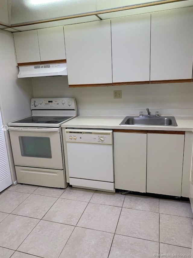 kitchen with light tile patterned floors, white appliances, and sink