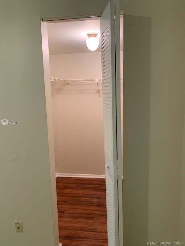 walk in closet with hardwood / wood-style flooring