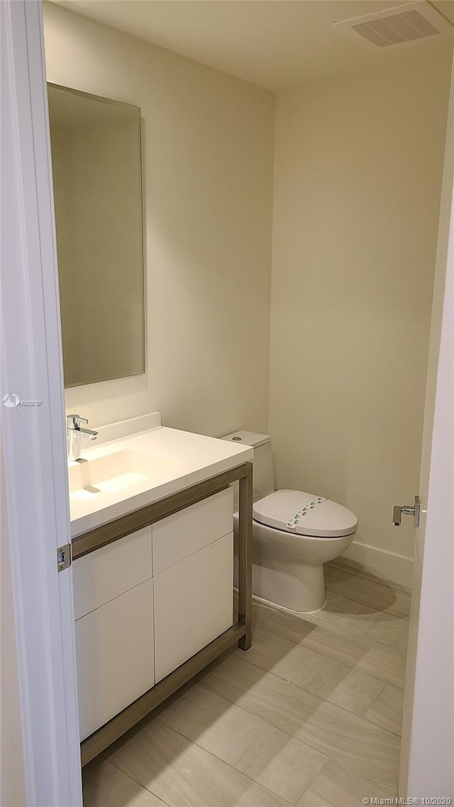 bathroom featuring vanity, tile patterned flooring, and toilet