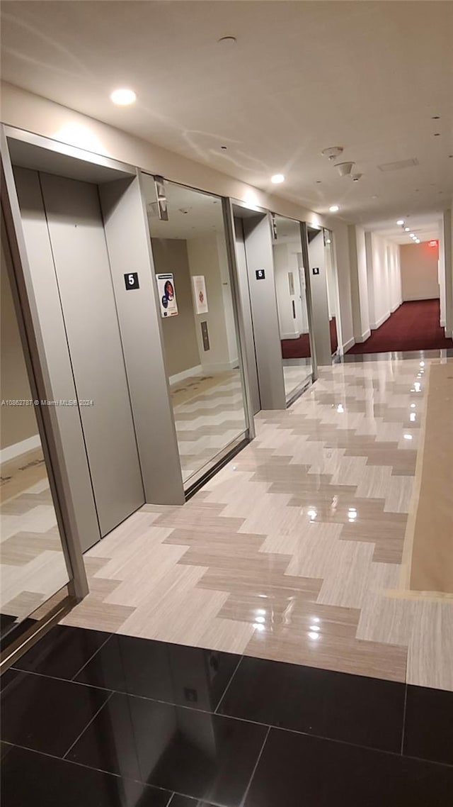 hallway featuring elevator and tile patterned flooring