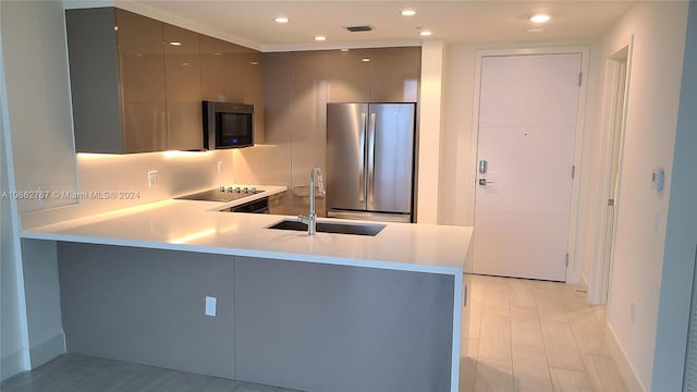 kitchen featuring light hardwood / wood-style flooring, backsplash, appliances with stainless steel finishes, sink, and gray cabinetry