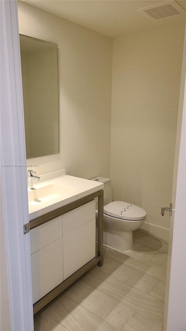 bathroom featuring tile patterned floors, vanity, and toilet