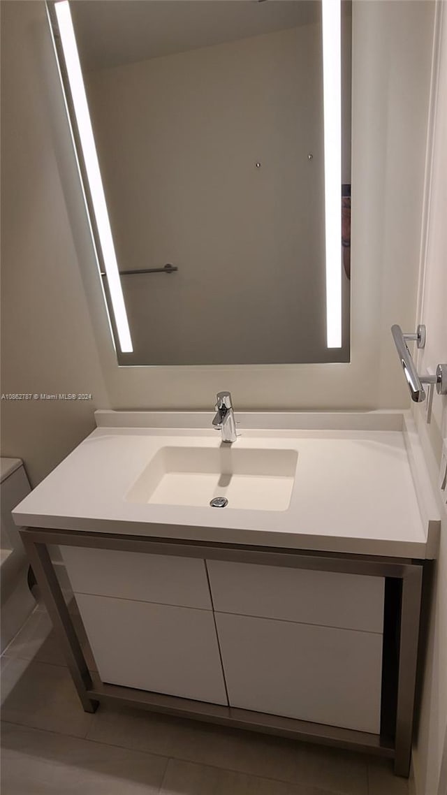 bathroom with tile patterned flooring, vanity, and toilet