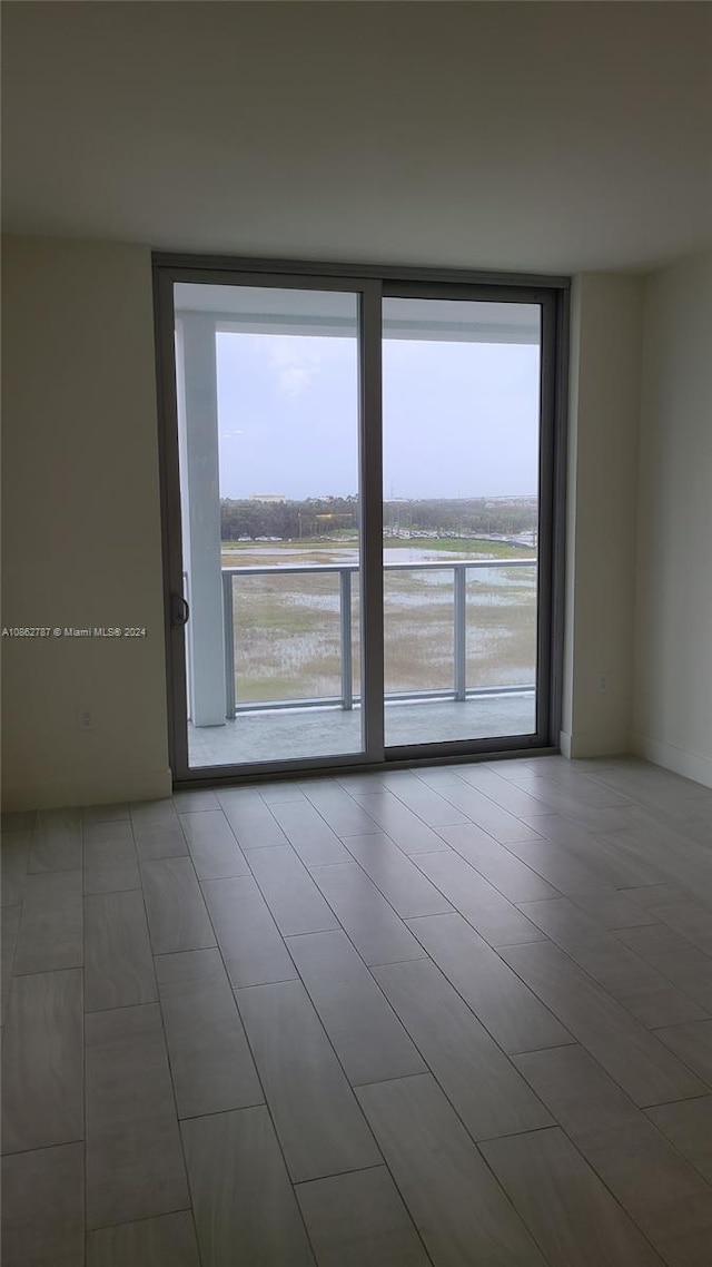 empty room featuring a water view and expansive windows