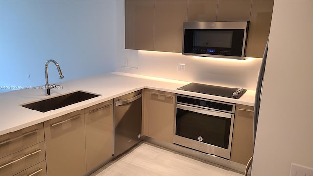 kitchen with sink, light wood-type flooring, stainless steel appliances, and gray cabinetry