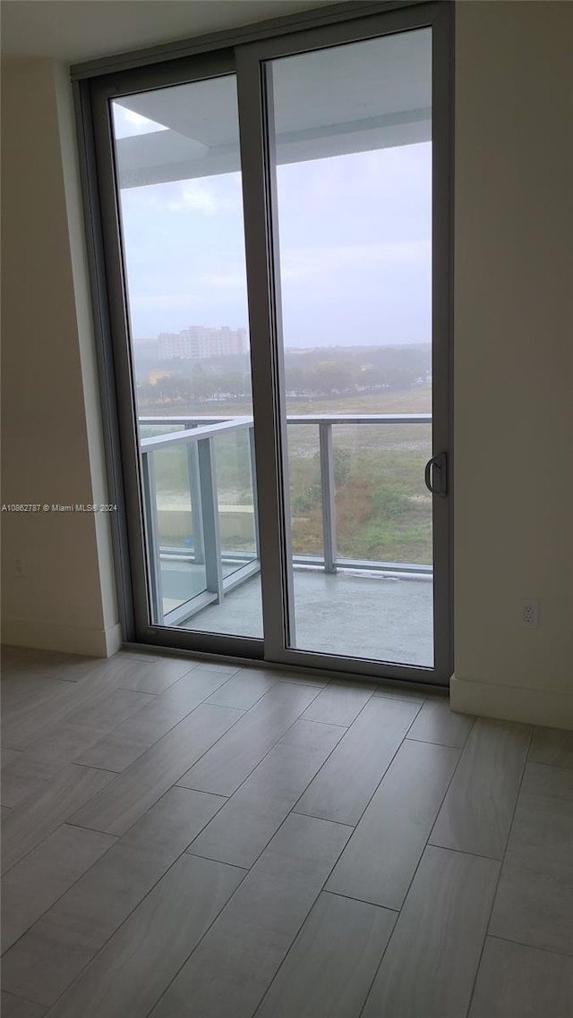 spare room with a wall of windows and a healthy amount of sunlight