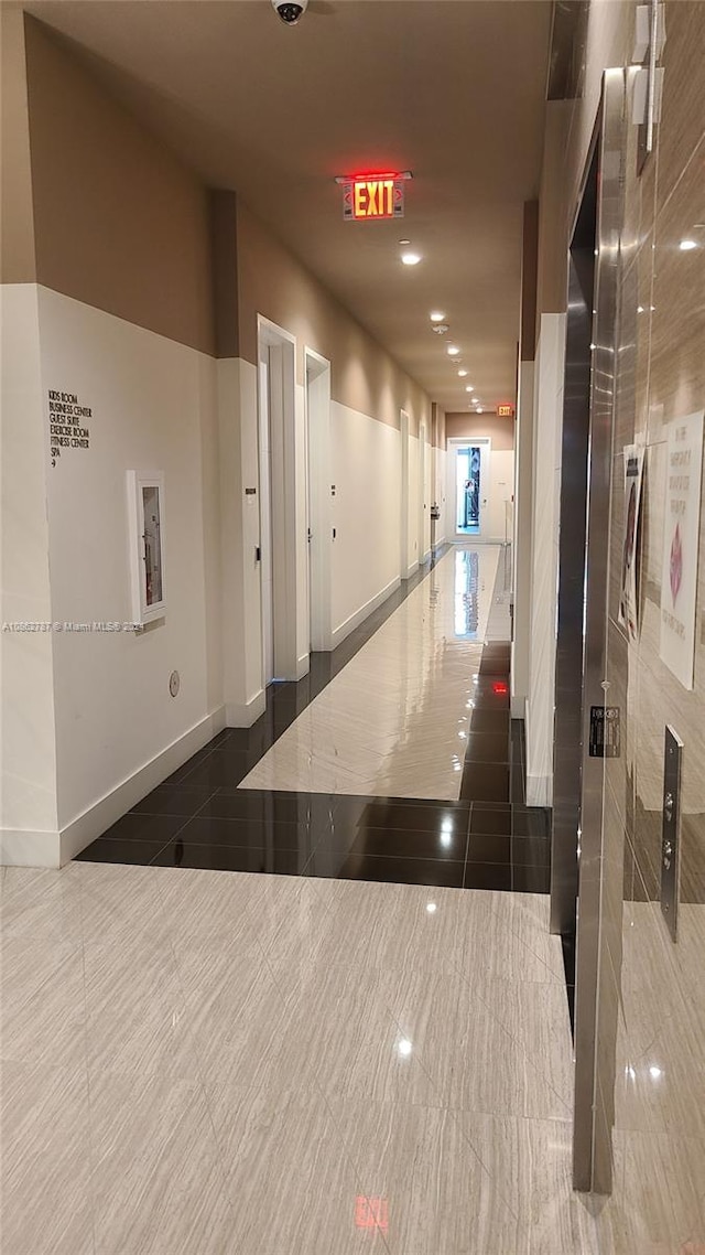 hallway featuring dark tile patterned floors