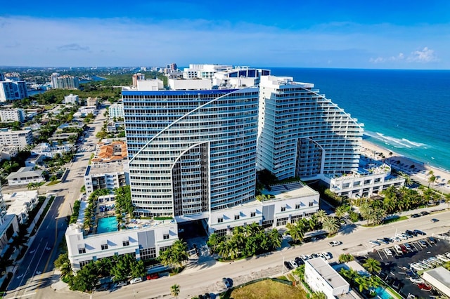 drone / aerial view with a water view, a view of the beach, and a city view