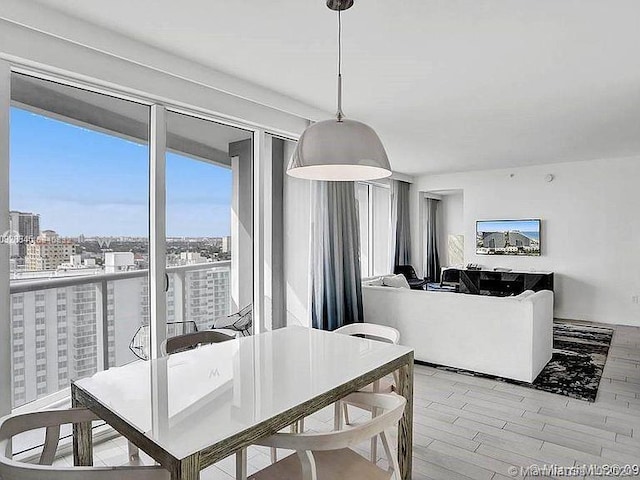 dining area with a view of city and light wood finished floors