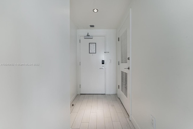 corridor with recessed lighting, visible vents, light wood-style flooring, and baseboards