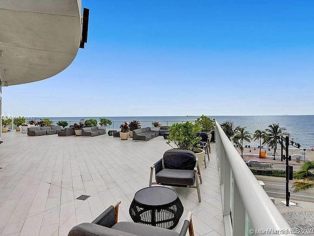 exterior space with a balcony, a water view, and an outdoor hangout area