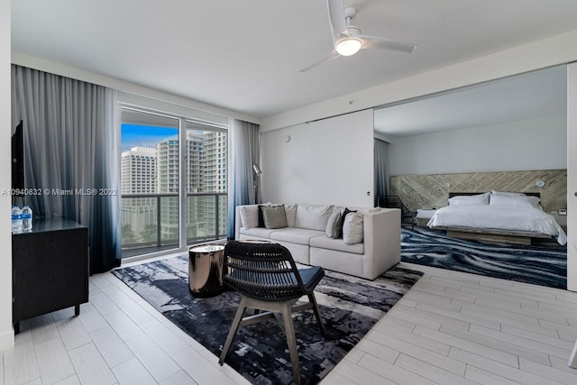 living room with a view of city, ceiling fan, and wood finished floors