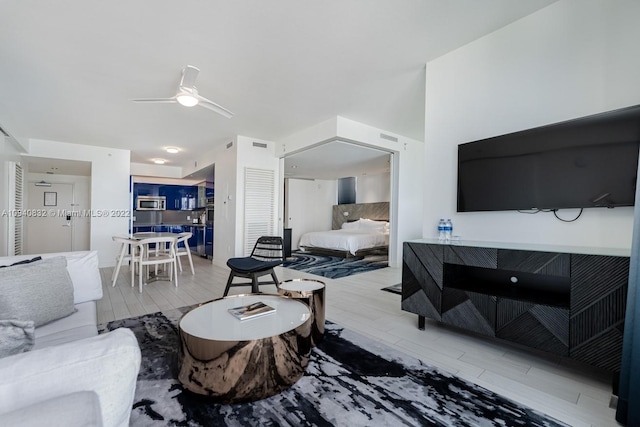 living room featuring ceiling fan and hardwood / wood-style flooring