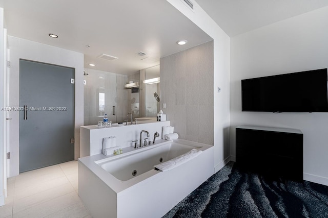 bathroom with tile patterned floors and a bath