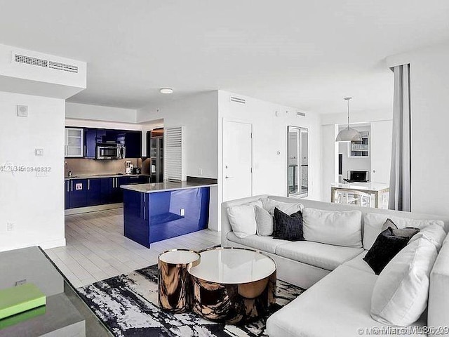 living area featuring visible vents and light wood finished floors