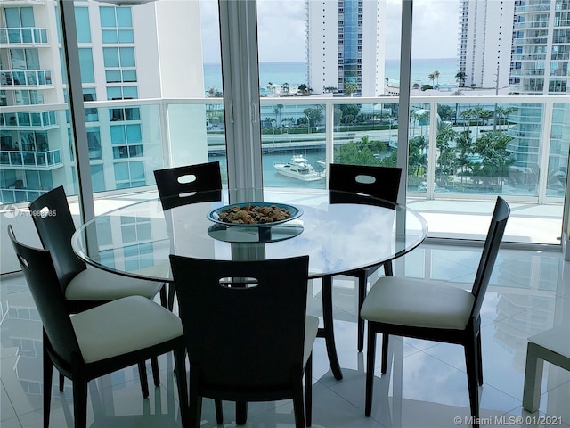 dining area featuring light tile flooring and a water view