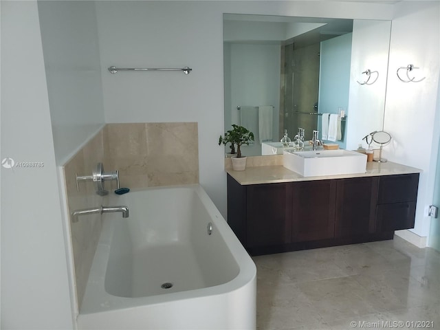 bathroom featuring a bathing tub, vanity, and tile flooring