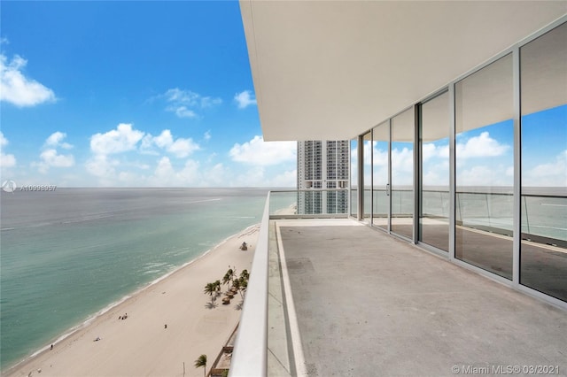 balcony featuring a water view and a view of the beach