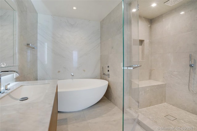 bathroom featuring plus walk in shower, tile floors, and tile walls