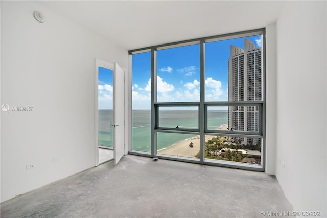 spare room featuring a water view and floor to ceiling windows