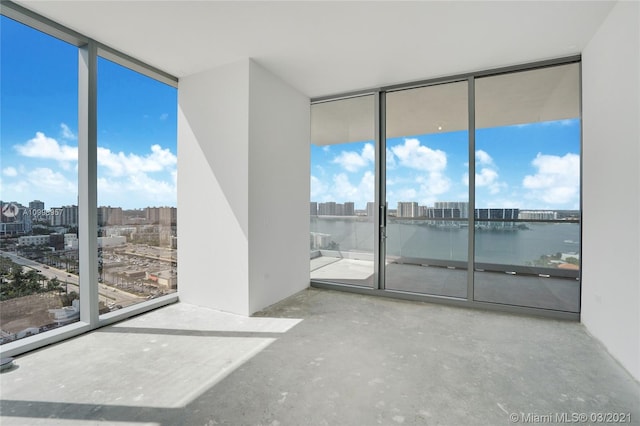 empty room with expansive windows, a wealth of natural light, and a water view