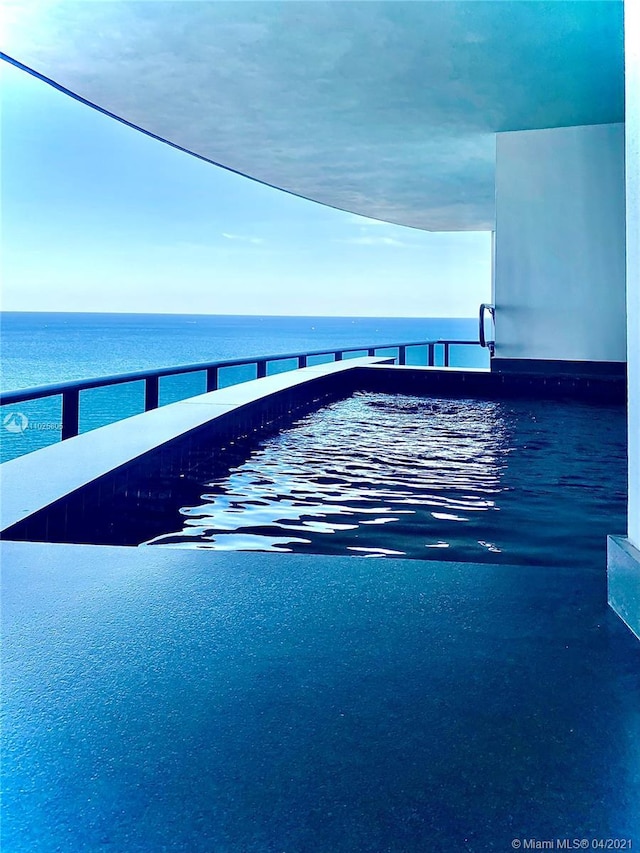 view of swimming pool featuring a water view