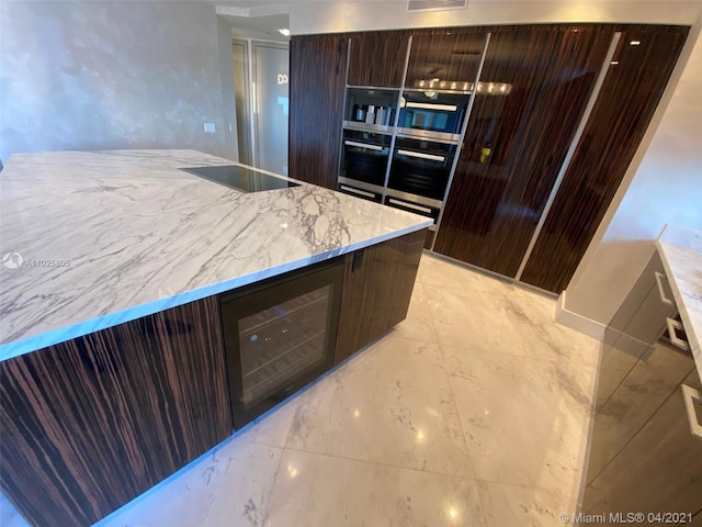 kitchen with black electric stovetop, light tile flooring, oven, and light stone counters