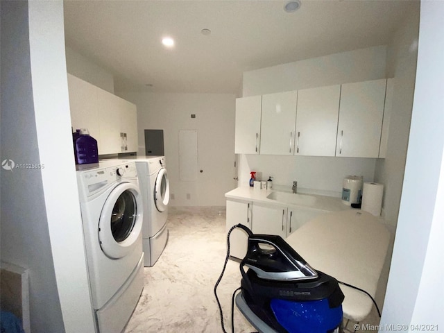 clothes washing area featuring cabinets, separate washer and dryer, and sink