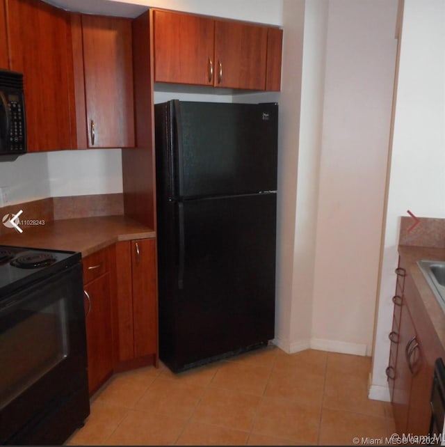 kitchen with light tile floors and black appliances