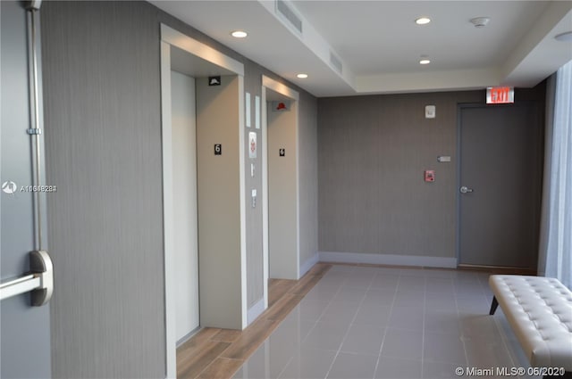 hallway featuring tile flooring and radiator heating unit