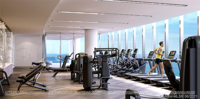 workout area featuring a wall of windows and a water view