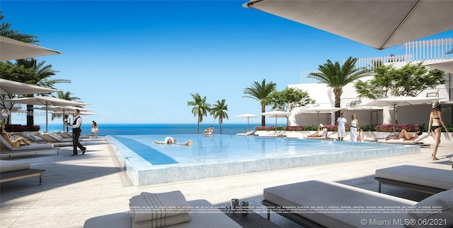 view of swimming pool featuring a patio and a water view