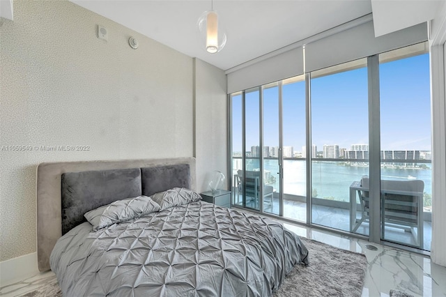 bedroom with a water view and multiple windows