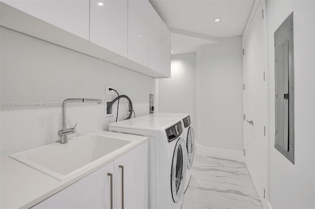 laundry area featuring cabinets, electric panel, sink, and washing machine and clothes dryer