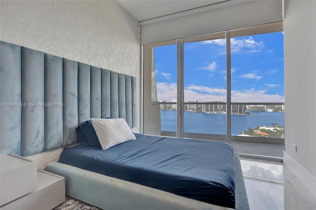 bedroom with multiple windows and a water view