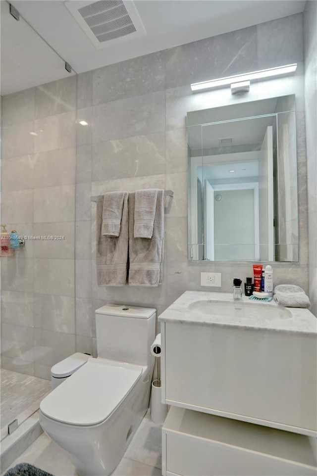 bathroom featuring tile walls, vanity, walk in shower, tile patterned flooring, and toilet