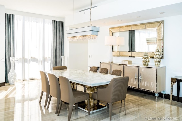 dining area featuring light wood-type flooring and a healthy amount of sunlight