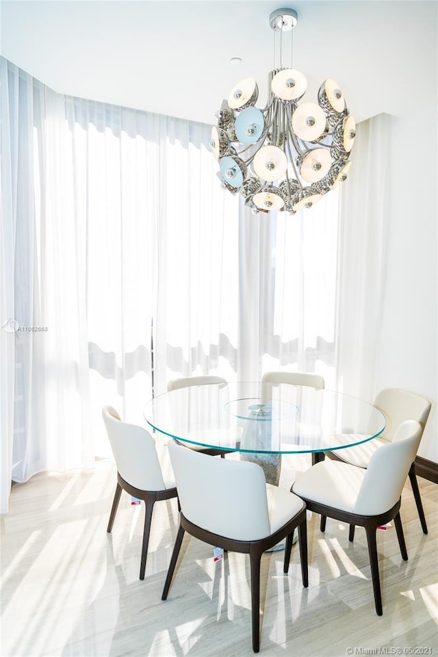 dining area featuring light hardwood / wood-style flooring and a chandelier