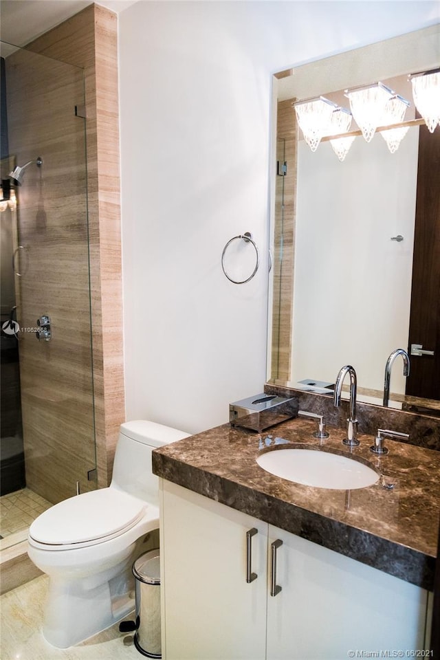 bathroom with a tile shower, vanity, and toilet