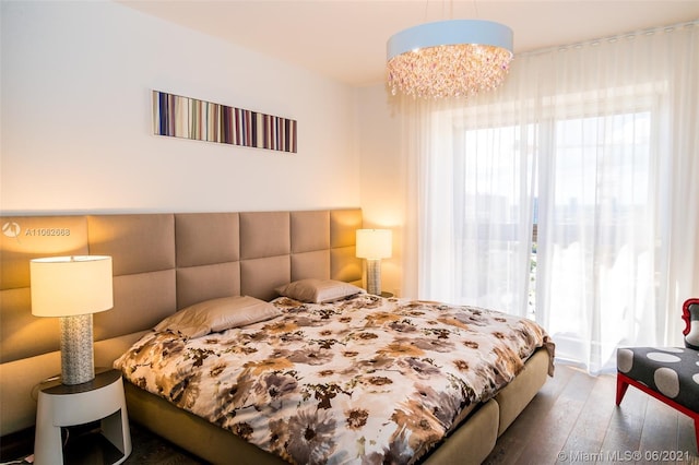 bedroom featuring dark hardwood / wood-style floors and a chandelier