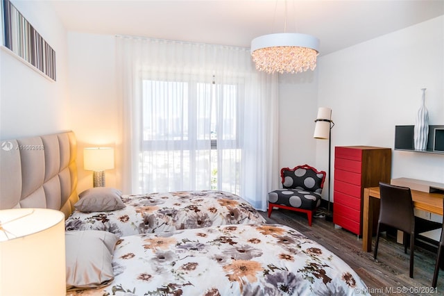 bedroom with an inviting chandelier and dark hardwood / wood-style floors