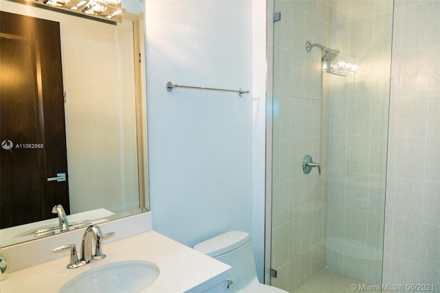 bathroom with vanity, a shower with shower door, and toilet